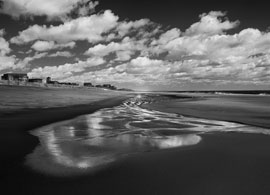 Black and white gallery print. Clouds over the ocean shore.